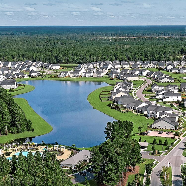 Aerial view of a large residential neighborhood with lakes, surrounded by forest, in a Lennar community.