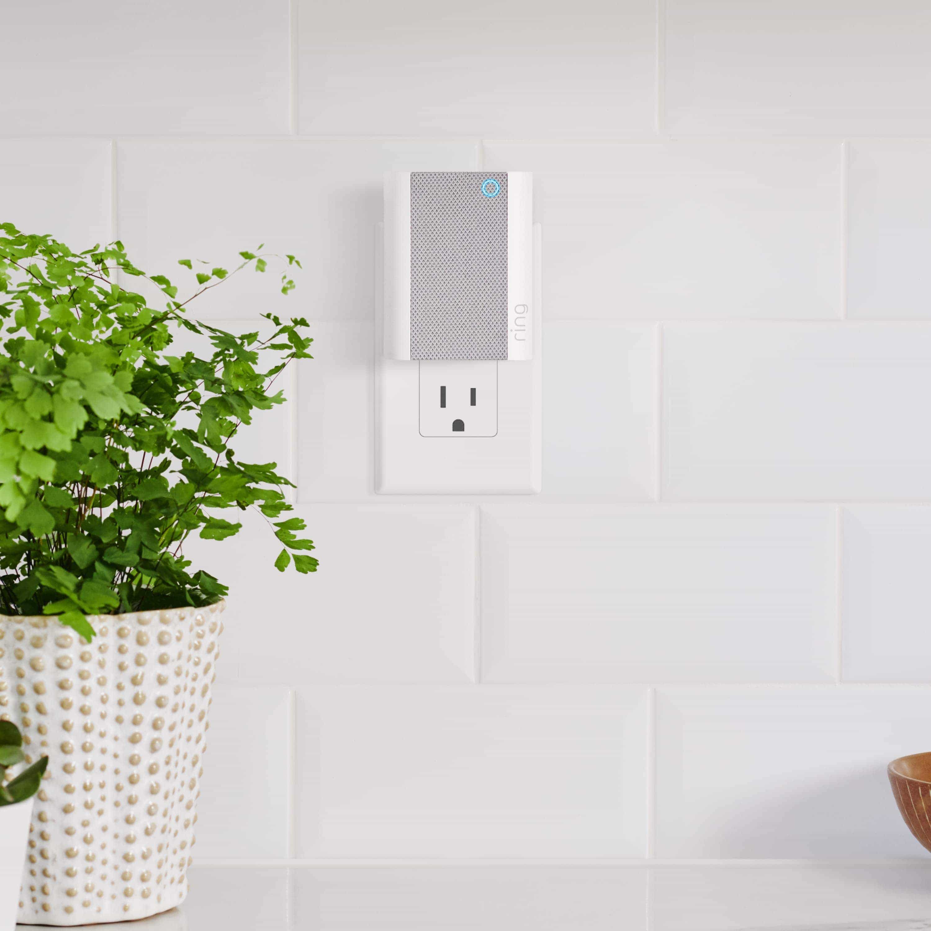 Chime - Ring Chime plugged into a kitchen wall outlet next to a white basket with a plant in it.