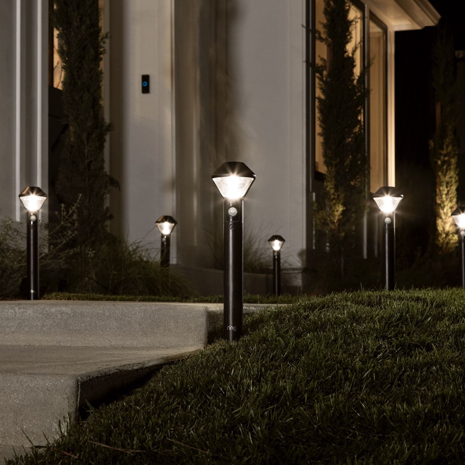 Smart Lighting Pathlight Battery - Multiple Ring Smart Lighting Pathlights line a walkway and stairs at night, automatically illuminating outdoor spaces.