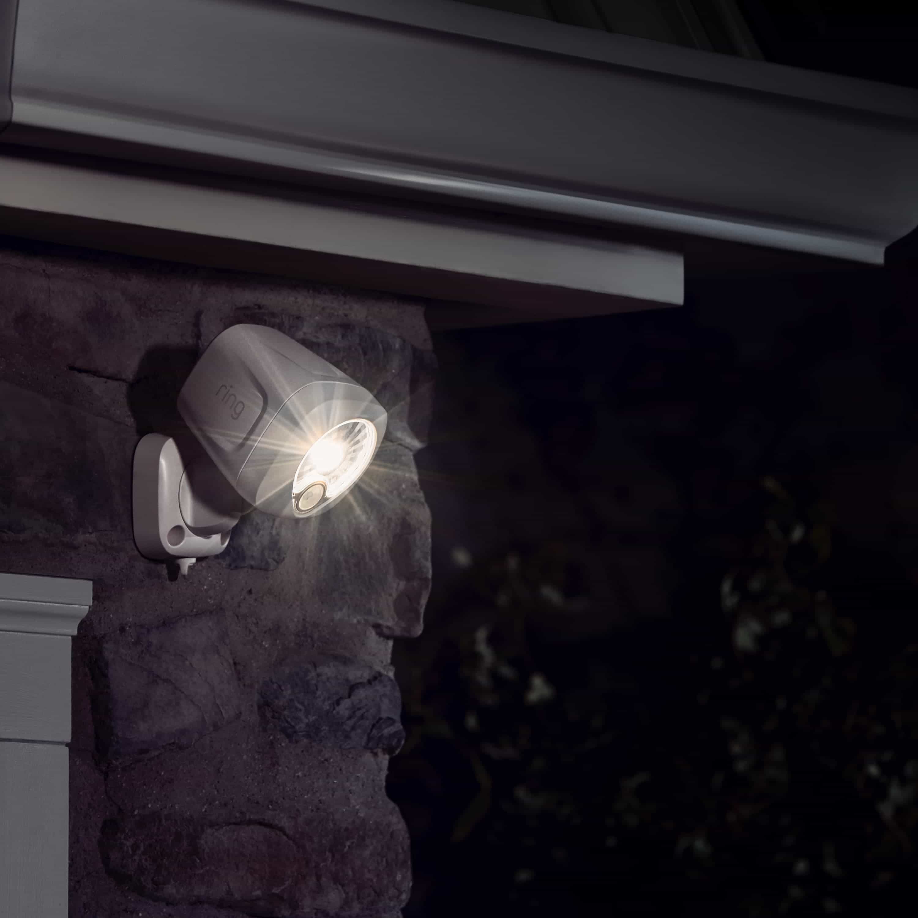 Smart Lighting Spotlight Battery - Ring battery-powered Smart Lighting Spotlight mounted on an exterior wall at night, shining a bright light.