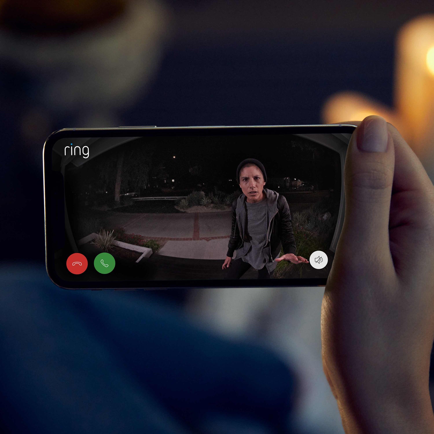 Video Doorbell Elite (Power over Ethernet) - Hand holding smartphone showing a live Ring Video Doorbell Elite feed of a person approaching front door at night.