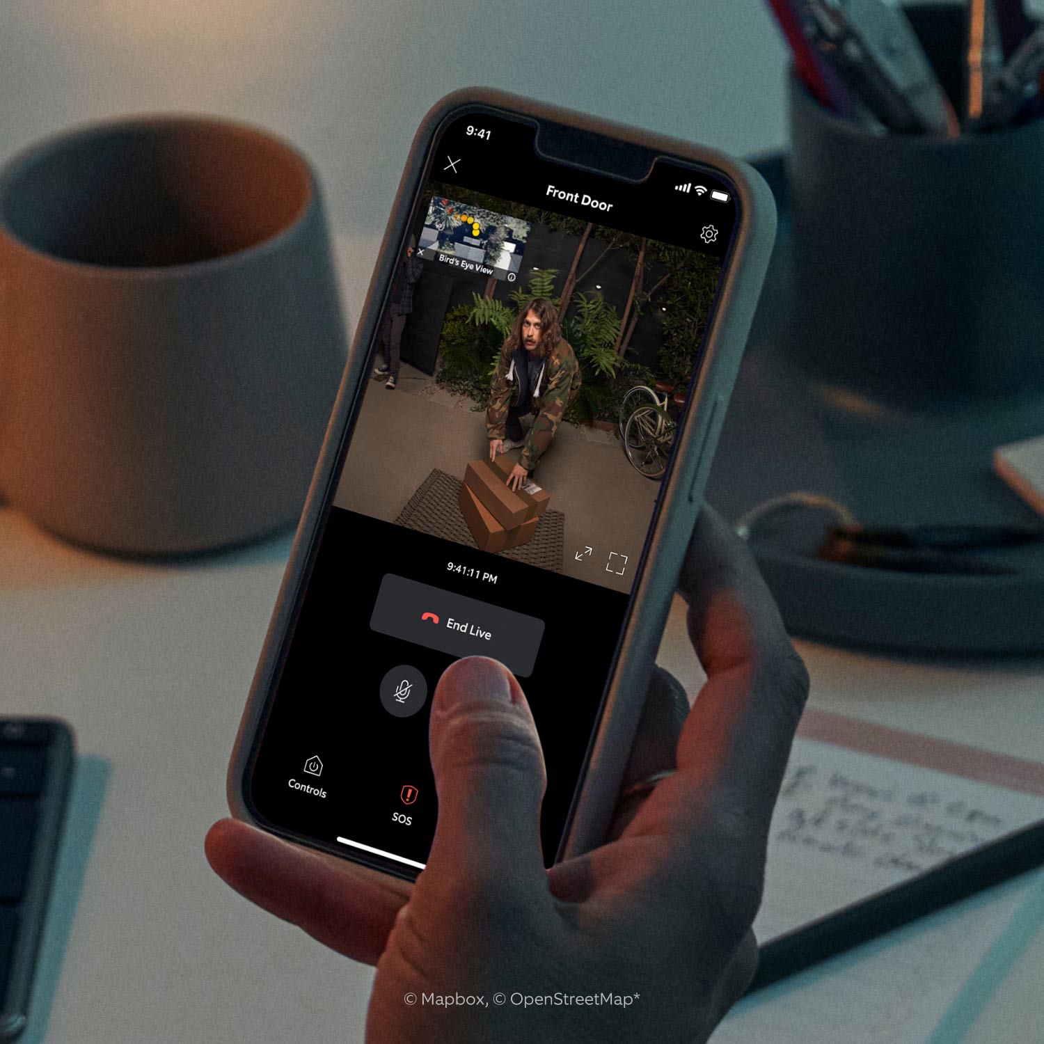 Battery Doorbell Pro + Spotlight Cam Plus Battery - Person monitors visitor movements via Ring App using Battery Doorbell Pro and Spotlight Cam Plus.