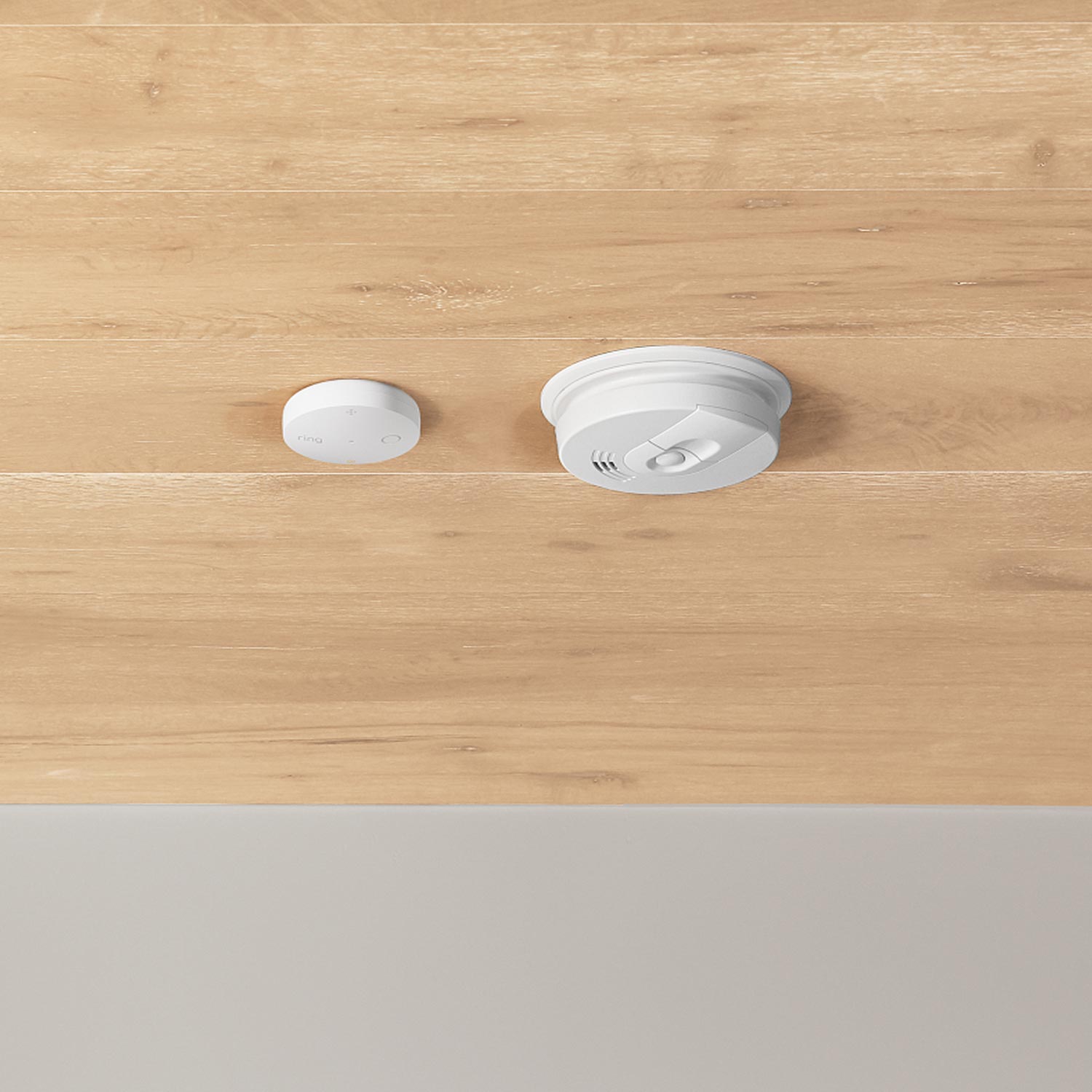 Smoke & CO Listener (Newest Model) - Two white smart home devices mounted on a wooden ceiling: a small sensor and a larger smoke detector.