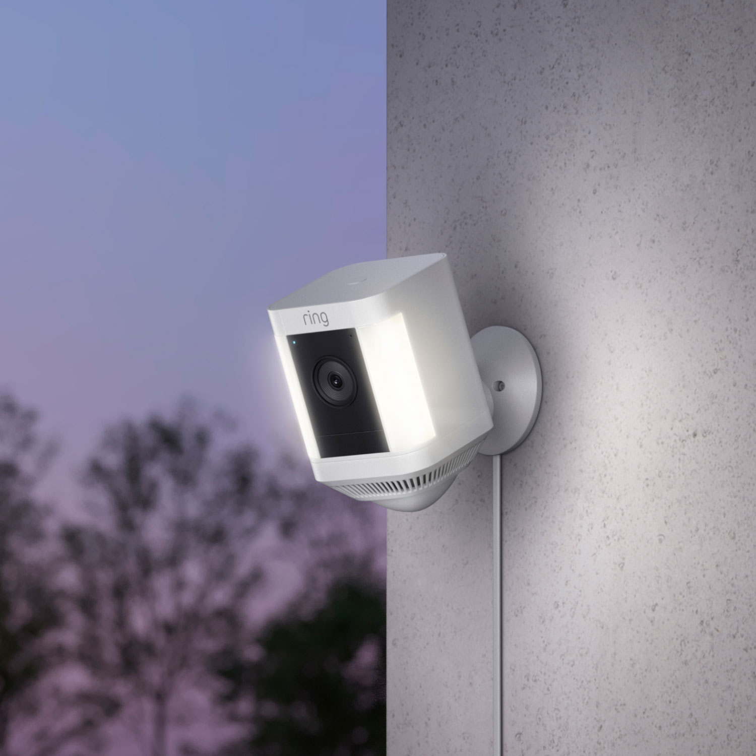 Pan-Tilt Indoor Cam + Spotlight Cam Plus Plug-In - White Ring Spotlight Cam Plus Plug-In on exterior wall at dusk, with built-in lights on.