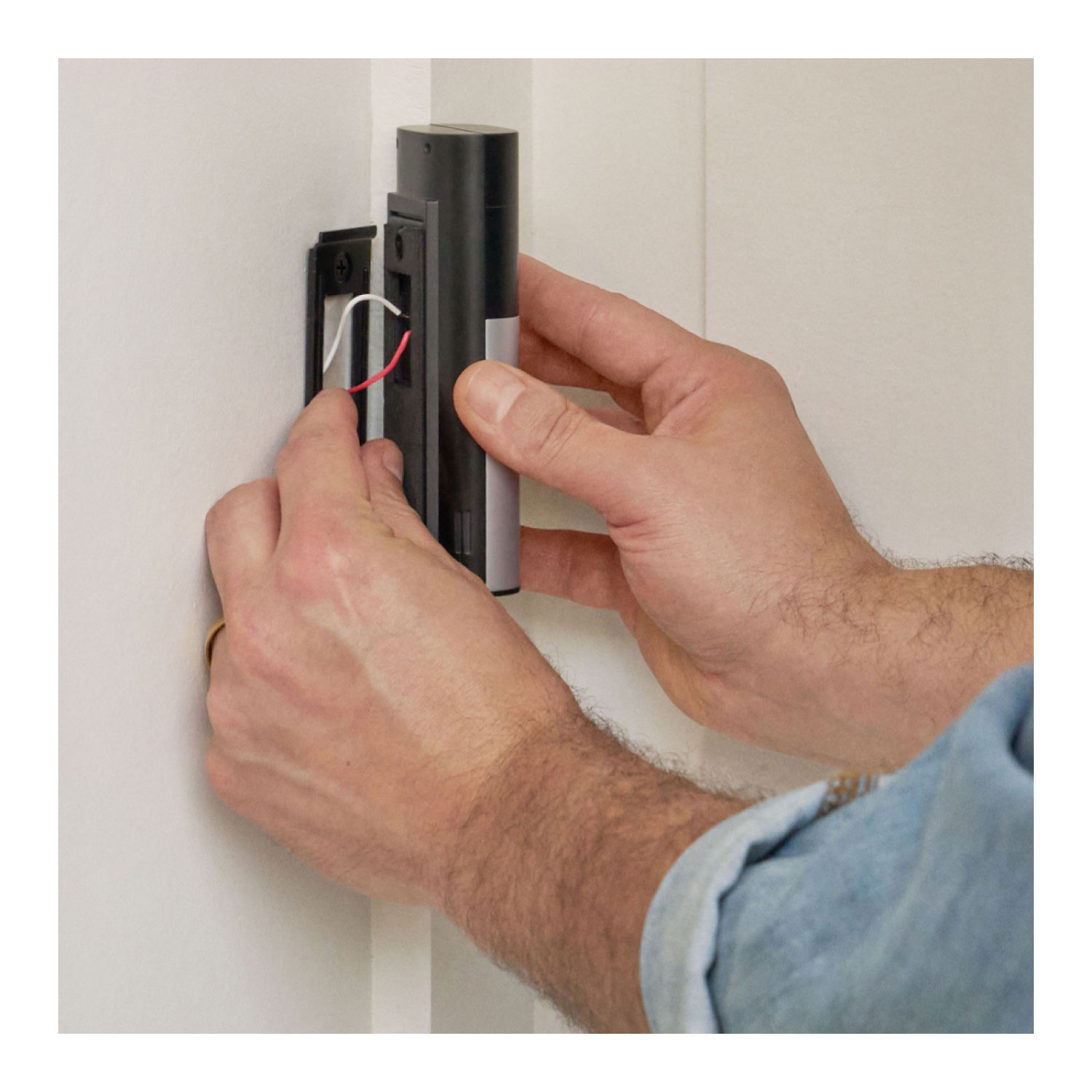 Wired Doorbell Plus (Newest Model) (Featuring Retinal 2K) - A person installing a Wired Doorbell Plus (2nd Gen), with their hands carefully mounting the device on a wall. 