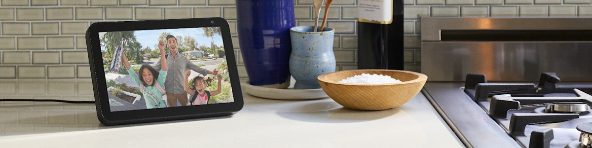 Amazon Echo Show on kitchen worktop next to wooden bowl and hob