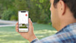 Person using mobile app outdoors with nature in background